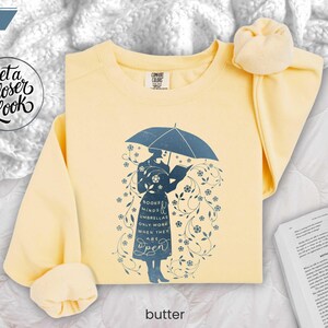 BUTTER folded flat lay warm yellow sweatshirt styled with soft blanket and book, inviting cozy classroom and weekend reading energy