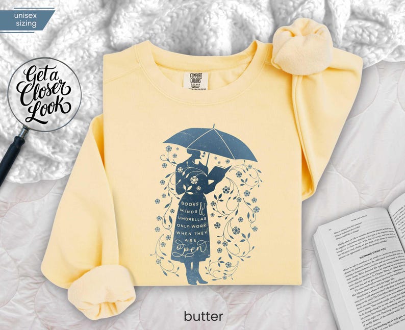 BUTTER folded flat lay warm yellow sweatshirt styled with soft blanket and book, inviting cozy classroom and weekend reading energy