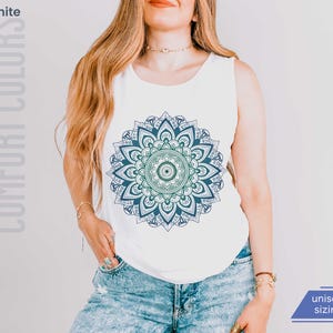 woman in comfort colors 9360 white tank top sleeveless tee with mandala graphic in blues and greens. Mandala contains hidden FDT, 8647, RESIST, and symbols of pro-choice.