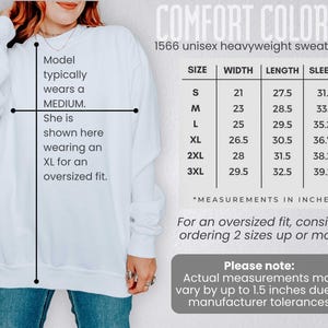 May include: White Comfort Colors 1566 unisex heavyweight sweatshirt. The image includes a size chart with measurements in inches for sizes S to 3XL. The model typically wears a medium and is shown wearing an XL for an oversized fit.
