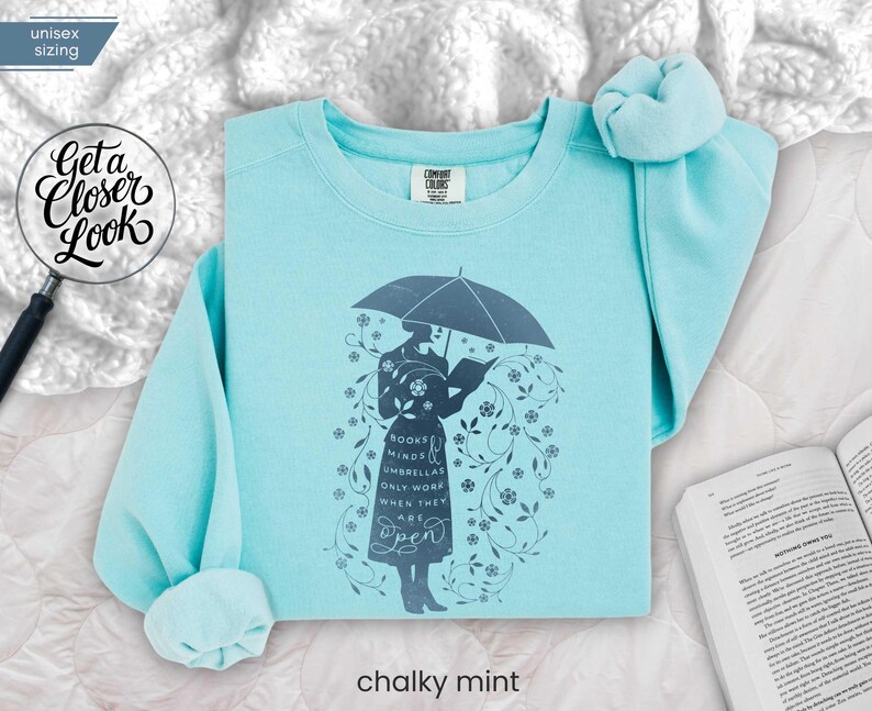 CHALKY MINT folded flat lay sweatshirt styled on plush blanket with reading accessories, perfect for winter classroom or library lounge vibes