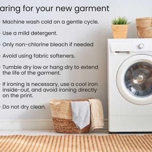 May include: Image with text: Caring for your new garment. Instructions include machine wash cold, use mild detergent, avoid fabric softeners, tumble dry low, and do not dry clean. A washing machine, laundry basket, and plant are also visible.