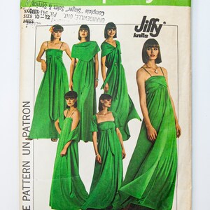 May include: A Simplicity sewing pattern for a green maxi dress. The pattern is for sizes 10-12 and is designed for stretch knits. The pattern is called "Jiffy knits" and is number 8086.