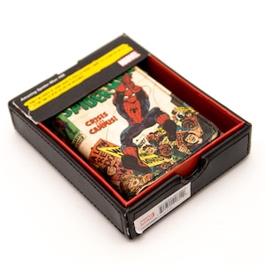 May include: A Marvel Spider-Man wallet featuring a comic book cover design, displayed in a black box with a red interior. The wallet showcases Spider-Man in action with the text "Crisis on Campus!"