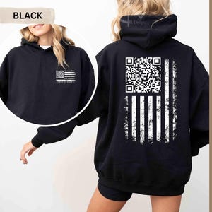 May include: Black hoodie with a distressed American flag design. The flag features a QR code in the upper left corner and white stripes. The hoodie has a front pocket and a hood. The word "BLACK" is in a banner in the upper left corner.