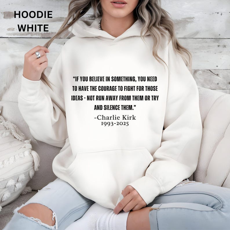 May include: A white hoodie with a quote by Charlie Kirk: "IF YOU BELIEVE IN SOMETHING, YOU NEED TO HAVE THE COURAGE TO FIGHT FOR THOSE IDEAS - NOT RUN AWAY FROM THEM OR TRY AND SILENCE THEM." The text is in black. The hoodie also has the text "HOODIE WHITE".