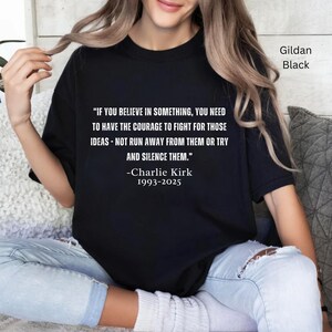 May include: Black Gildan t-shirt with a quote by Charlie Kirk: "IF YOU BELIEVE IN SOMETHING, YOU NEED TO HAVE THE COURAGE TO FIGHT FOR THOSE IDEAS - NOT RUN AWAY FROM THEM OR TRY AND SILENCE THEM." The quote is in white text.