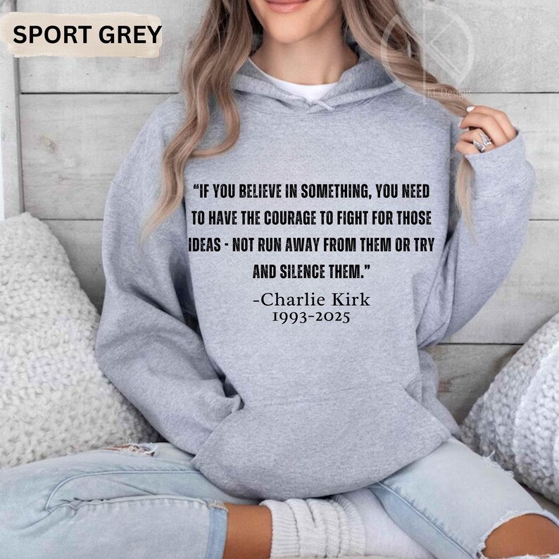 May include: Sport grey hoodie with the quote "IF YOU BELIEVE IN SOMETHING, YOU NEED TO HAVE THE COURAGE TO FIGHT FOR THOSE IDEAS - NOT RUN AWAY FROM THEM OR TRY AND SILENCE THEM." by Charlie Kirk, 1993-2025. The hoodie is a light grey color.