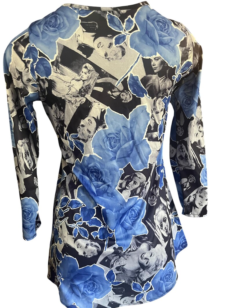 May include: A long-sleeved top featuring a collage of vintage black and white images of women, overlaid with large blue rose floral patterns. The top has a scoop neck and a flowing, slightly flared shape.