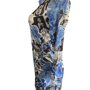 May include: Long-sleeved shirt with a unique design. The shirt features a collage of black and white images of a woman, with large blue rose illustrations. The shirt has a round neckline and a fitted silhouette.