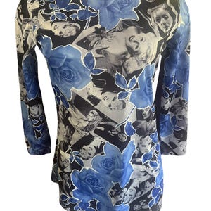 May include: A long-sleeved top with a unique pattern. The design features a collage of black and white images of women, overlaid with blue roses. The top has a scoop neck and a fitted silhouette.