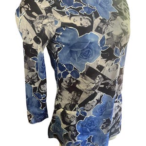May include: A long-sleeved top featuring a collage of black and white images and large blue rose patterns. The top has a round neckline and a fitted silhouette, with the floral design adding a touch of elegance.