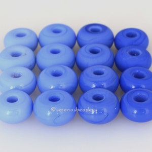 Peut inclure: Un ensemble de 12 perles en verre bleu clair avec un trou au centre. Les perles sont disposées en forme de carré.