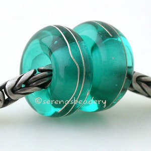 May include: Two teal blue glass beads with silver lines on a silver chain. The beads are round and have a shiny finish.