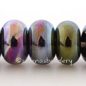 May include: Five iridescent glass beads in shades of green, purple, and blue. The beads are round and have a smooth, glossy finish.