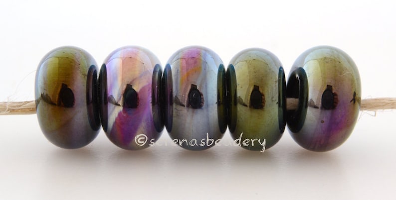 May include: Five iridescent glass beads in shades of green, purple, and blue. The beads are round and have a smooth, glossy finish.