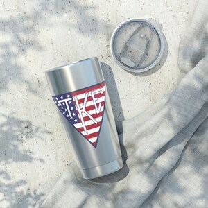 May include: A stainless steel tumbler with a white and red American flag design and the letters "TKE" in white. The tumbler has a lid.