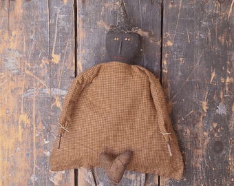 Muñeca de bruja de pared primitiva con guirnalda de corazones desgastada y sucia.