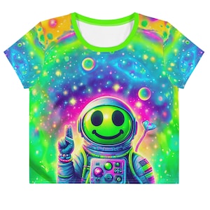 Könnte beinhalten: Ein T-Shirt mit Galaxie-Druck in Grün, Blau und Pink mit einem lächelnden Astronauten, der einen Raumanzug trägt. Der Astronaut zeigt mit einer Hand ein Peace-Zeichen und hält in der anderen Hand ein herzförmiges Objekt.