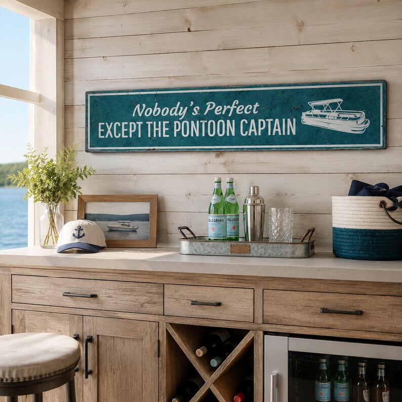 Op de afbeelding: Een rechthoekig blauwgroen wandbord met een witte rand en witte tekst die Nobody's Perfect EXCEPT THE PONTOON CAPTAIN luidt, voorzien van een witte lijntekening van een pontonboot aan de rechterkant tegen een verweerde achtergrond.