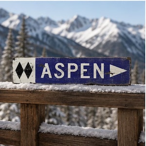 Peut inclure: Un panneau rectangulaire en bois avec une finition bleue vieillie et des lettres blanches indiquant ASPEN. Le panneau présente deux symboles de losanges noirs sur le côté gauche et une flèche directionnelle blanche sur la droite.