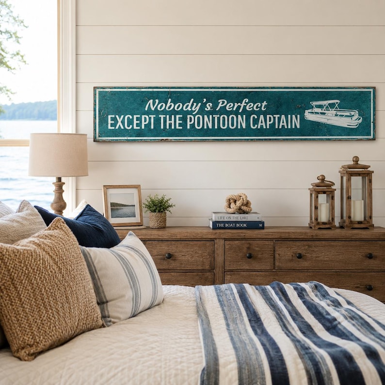 Op de afbeelding: Een lang, rechthoekig houten bord in een blauwgroene kleur met een verweerde afwerking. Het bord bevat witte tekst met de tekst "Nobody's Perfect EXCEPT THE PONTOON CAPTAIN" en een witte lijntekening van een pontonboot aan de rechterkant.