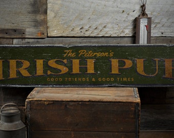 Può includere: Un cartello in legno verde con bordo nero e lettere dorate che recita "The Peterson's Irish Pub Good Friends & Good Times".