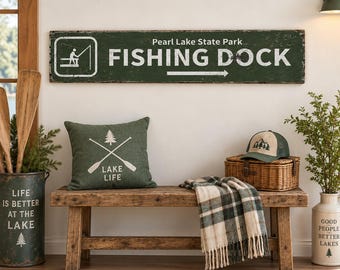 Puede incluir: Un letrero rectangular de madera verde oscuro con texto blanco que dice Pearl Lake State Park FISHING DOCK y un icono blanco de una persona pescando. El letrero presenta una flecha blanca que apunta a la derecha y un acabado desgastado.
