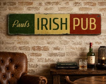 May include: A rectangular wooden sign featuring a distressed finish with vertical stripes in green, yellow, and red. The text "Paul's IRISH PUB" is printed in a bold, dark font across the center, mimicking the colors of the Irish national flag.