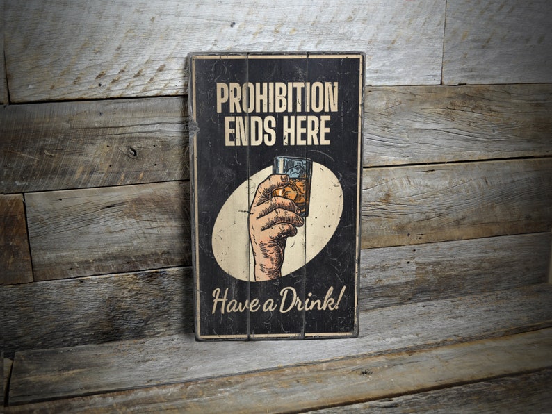 a sign on a wooden wall that says prohibition ends here have a drink