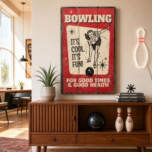 May include: A rectangular wall sign with a red background and a cream-coloured centre panel featuring a black illustration of a person bowling. The text reads BOWLING IT'S COOL IT'S FUN! FOR GOOD TIMES & GOOD HEALTH with star accents.