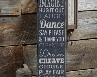 May include: A dark blue wooden sign with white text that reads "Playroom Rules" and lists a set of rules for children, including "Be Kind", "Share", "Imagine", "Hug It Out", "Laugh", "Dance", "Say Please & Thank You", "Clean Up", "Dream", "Create", "Giggle", "Play Fair", "Sing Songs", "Say You're Sorry", "Welcome Everyone", "Be Honest", and "Love".