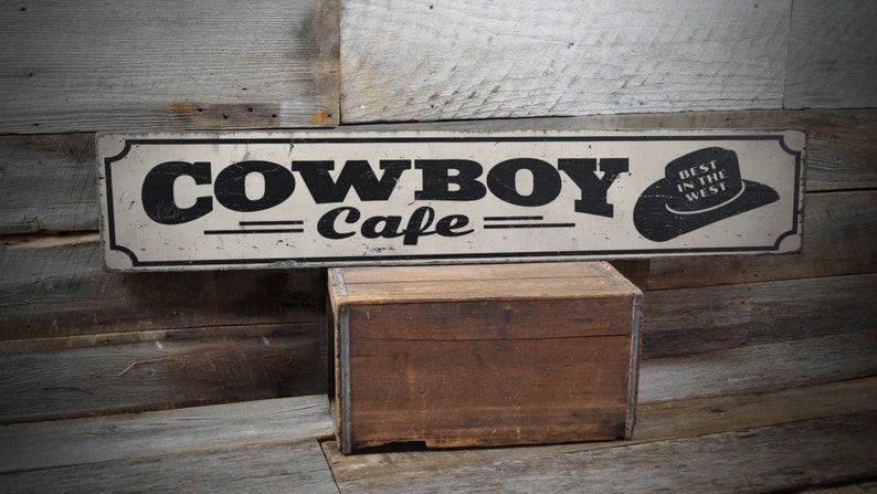 a cowboy cafe sign on a wooden wall