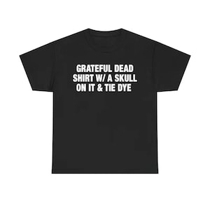 May include: Black t-shirt with white text that reads "Grateful Dead Shirt W/ A Skull On It & Tie Dye." The shirt is a crew neck style and appears to be made of a soft material. The text is centered on the front of the shirt.