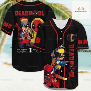 Può includere: Maglia da baseball nera con bordini rossi che presenta immagini di cartoni animati di Deadpool e Wolverine. La maglia ha le parole "DEADPOOL" sul davanti e sul retro, e i nomi "HUGH JACKMAN" e "RYAN REYNOLDS" con le loro firme sotto le immagini.