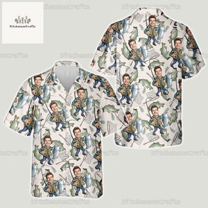 Könnte beinhalten: Ein weißes Hemd mit Knöpfen und einem sich wiederholenden Muster von Cartoon-Fischern, die Fische und Fischernetze halten. Die Fischer tragen alle grüne Westen und Hüte. Das Hemd hat kurze Ärmel und einen Kragen.