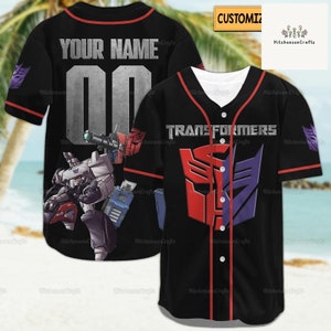 Puede incluir: Jersey de béisbol negro con ribetes rojos. La parte delantera del jersey presenta el logotipo de Transformers y la parte posterior tiene el texto "YOUR NAME" y el número "00".