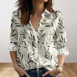 Può includere: Camicia bianca con bottoni con motivo a ramo d'ulivo verde. La camicia a maniche lunghe presenta un colletto classico e polsini con bottoni. Il design del ramo d'ulivo comprende foglie verdi e olive nere.