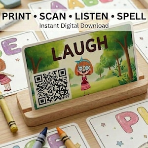 May include: A rectangular educational card featuring the word LAUGH in bold brown letters, a QR code, and a cartoon illustration of a girl with glasses in a park. The card is displayed in a light-colored wooden stand, surrounded by other illustrated cards and crayons.