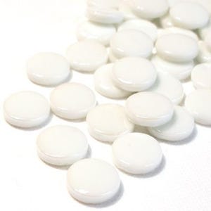 May include: A collection of small, round, white glass mosaic tiles. The tiles are smooth and glossy, with a slightly domed shape. They are scattered across a white surface, creating a bright and clean aesthetic. Ideal for craft projects.