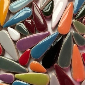 May include: Assortment of colourful ceramic teardrop-shaped tiles. The tiles are in various shades of blue, green, red, orange, purple, and grey.