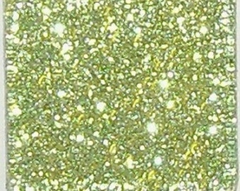 Könnte beinhalten: Eine quadratische Fliese mit grünem Glitzerfinish. Die Fliese ist aus Glas und hat eine glatte Oberfläche.