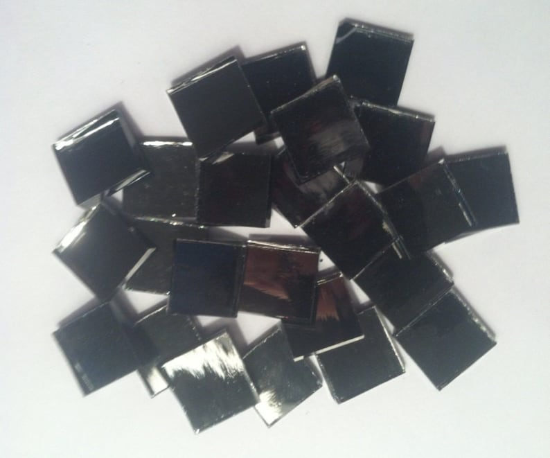 May include: A pile of small, square, black mirror tiles.