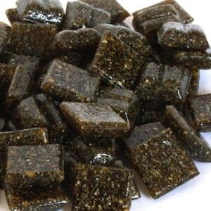 May include: A pile of small, square, dark brown glass tiles with a speckled, glittery finish.