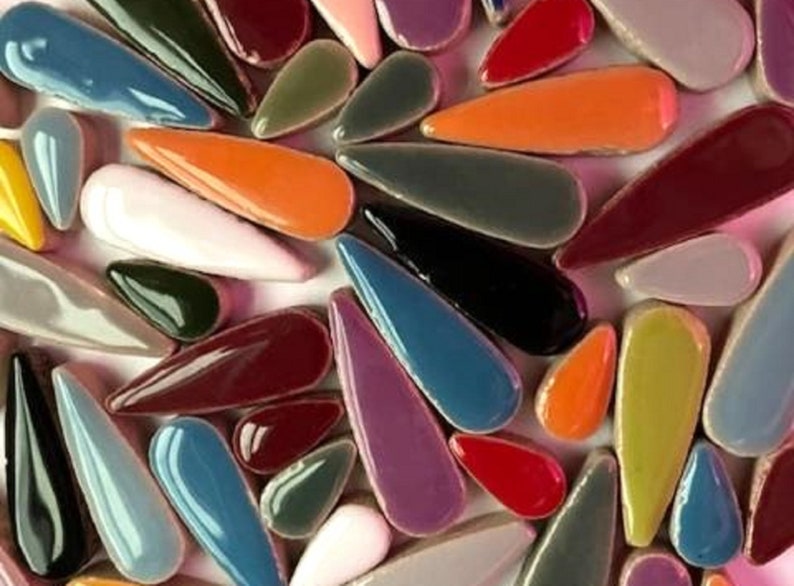 May include: Assortment of colourful ceramic teardrop-shaped tiles in various shades of blue, green, red, purple, orange, yellow, and brown.