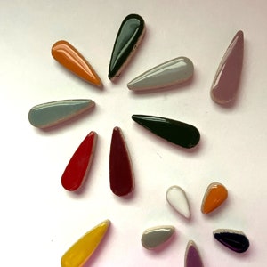 May include: Assortment of ceramic teardrop-shaped tiles in various colours, including red, orange, yellow, green, blue, purple, and white.