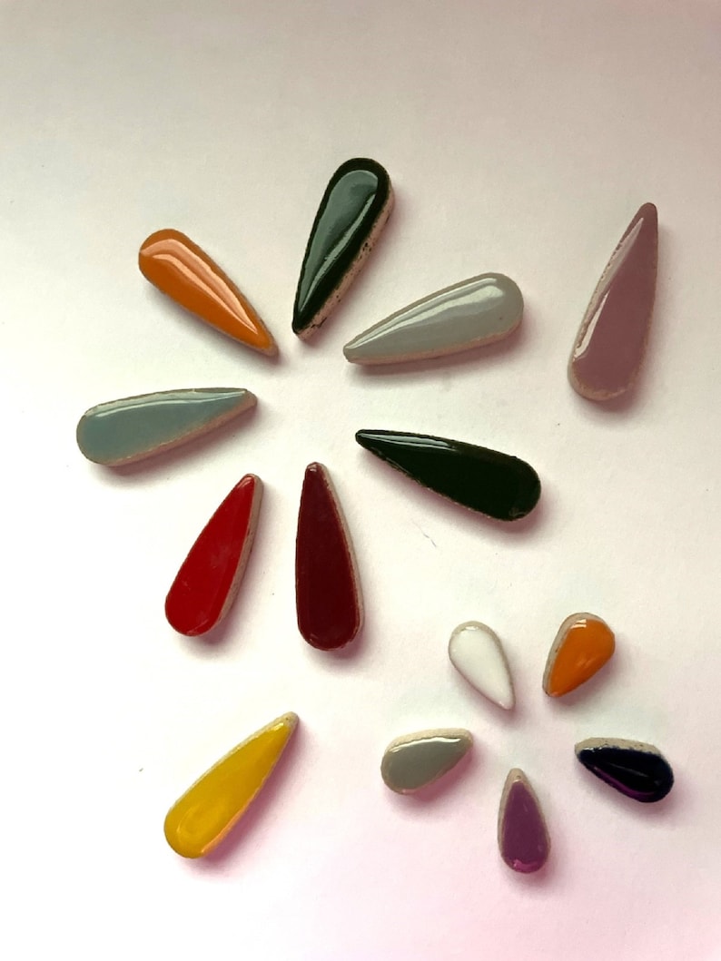 May include: Assortment of ceramic teardrop-shaped tiles in various colours, including red, orange, yellow, green, blue, purple, and white.