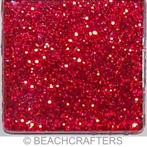 May include: A square tile with a red glitter finish. The tile is made of glass and has a smooth, shiny surface.