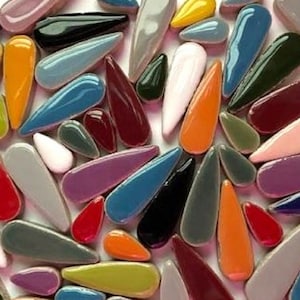 May include: A collection of colourful teardrop-shaped ceramic tiles in various shades of red, orange, yellow, green, blue, purple, pink, and grey.