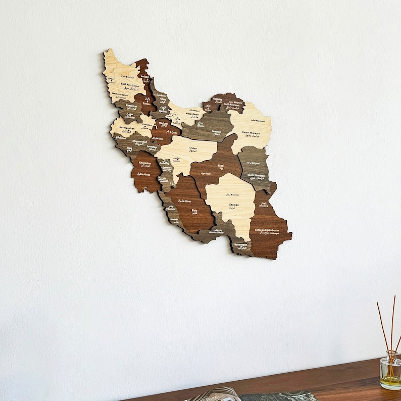 May include: A wooden map of Iran with the names of each province in Persian script. The map is made of different shades of wood, giving it a unique and rustic look.